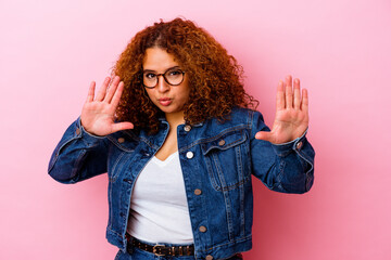 Young latin curvy woman isolated on pink background rejecting someone showing a gesture of disgust.
