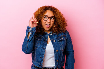 Young latin curvy woman isolated on pink background indicates with both fore fingers up showing a...