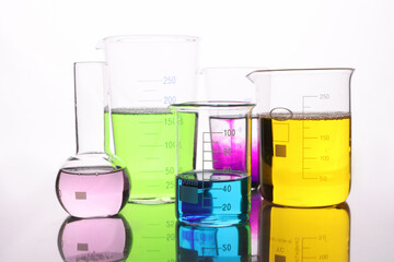 Glass flasks with multi-colored liquid on table