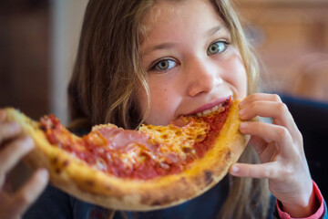 portrait of a pretty young girl devouring a pizza