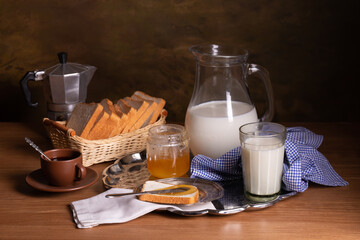 Still life with milk, honey bread and a coffee pot on a table
