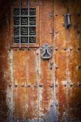 ancient wooden door with a metall lattice. Close up
