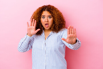 Young latin curvy woman isolated on pink background being shocked due to an imminent danger