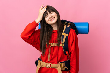 Mountaineer Ukrainian girl with a big backpack isolated on pink background laughing