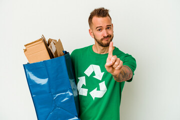 Young caucasian tattooed man recycled cardboard isolated on white background showing number one with finger.