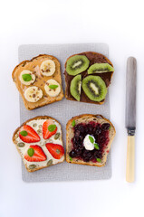 Fototapeta na wymiar healthy snack toast with fruit filling and seeds on a board and a knife