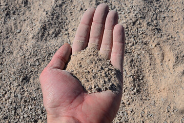a man's hand buried in an accident that brings earthquakes or mining accidents. in fine gravel...