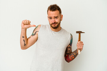 Young tattooed caucasian man isolated on white background feels proud and self confident, example...