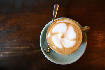 Top view of a hot coffee latte art on wooden table