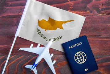 Gordijnen Flag of Cyprus with passport and toy airplane on wooden background. Flight travel concept.  © mirsad