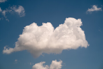 Obraz premium Puffy white cloud on a blue sky background.