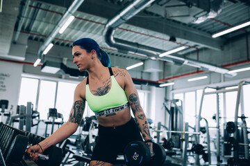 Fototapeta na wymiar tattooed woman workout in gym