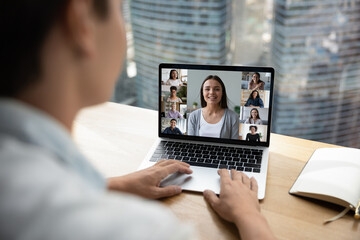 Back view of businessman talk speak on webcam video call with multiracial diverse colleagues on laptop. Multiethnic employees workers have digital web zoom online virtual meeting on computer.