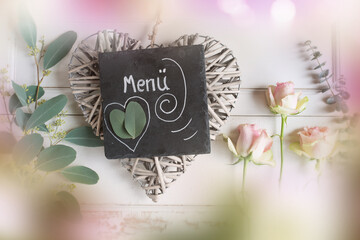 Atmospheric decoration for a mothers day set menu with tender roses and a heart on white vintage...