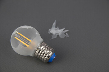 broken energy-saving light bulb on a dark background