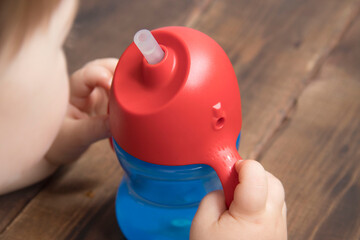 baby holding a water bottle with two hands