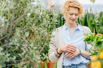 Olive branch in female hands. Home and Garden concept.