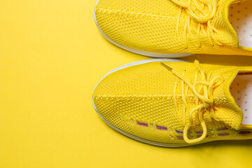 Yellow sneakers on a yellow background. Sports shoes. Healthy lifestyle concept