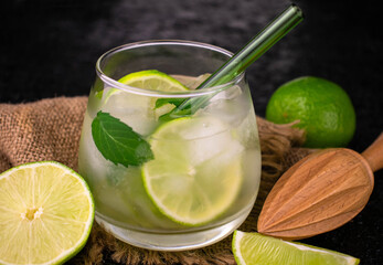 A glass of refreshing mojito on a black background.
Close-up.