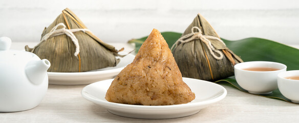 Zongzi. Rice dumpling for Dragon Boat Festival on bright wooden table background.