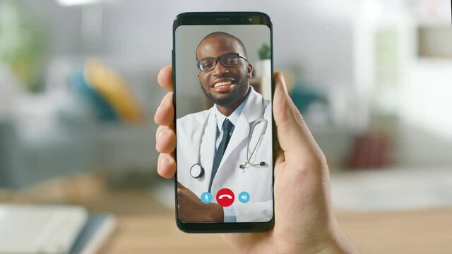 Point of View: Man Using Smartphone to Talk to His Doctor via Video Conference Medical App. Person Checks Symptoms, Talks with Physician, Using Online Video Chat Application. Close-up POV Camera.