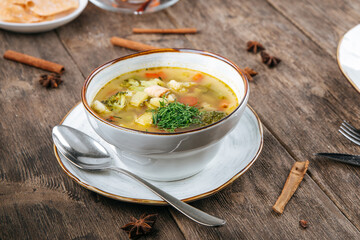 Bowl of vegetable soup with chicken on the wooden table