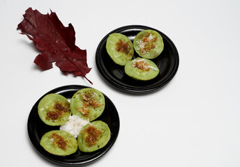 Balinese snack called Laklak, it is made from panda leaf dough, serve with coconut grater and brown sugar