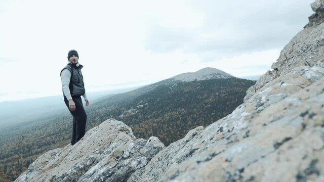 Hicker Standing On The Top Of The Cliff Looking Sideways Enjoying The Mountain Scenery. Travel Concept Active People on the Way to Victory Move Forward