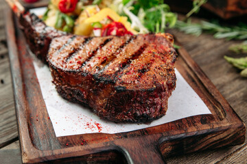 Closeup on juicy grilled beef steak on a wooden board