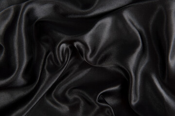 Abstract black silk fabric texture background. Cloth soft wave. Creases of satin