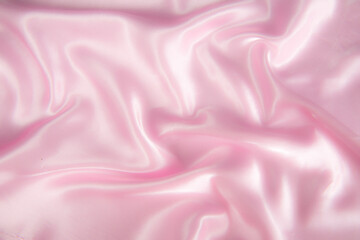 Abstract pink silk fabric texture background. Cloth soft wave. Creases of satin