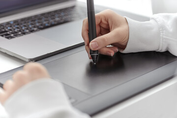 A female draw on a graphic tablet.