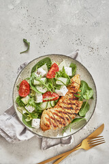Fried chicken fillet and fresh vegetable salad with feta cheese