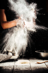 Obraz premium Baker hands sprinkling with flour pizza preparation