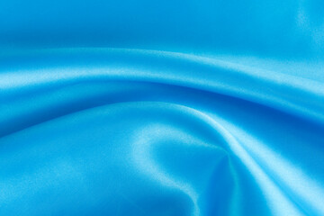 Abstract blue silk fabric texture background. Cloth soft wave. Creases of satin