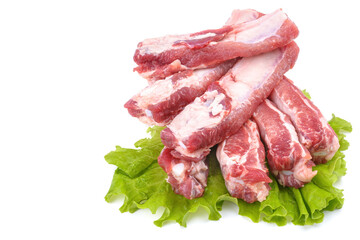 Sliced pork ribs on a lettuce leaf are isolated on a white background.Preparation of meat dishes.