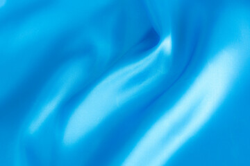 Abstract blue silk fabric texture background. Cloth soft wave. Creases of satin