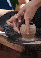 Making ceramics on a potter's wheel. Potter's hands close up.