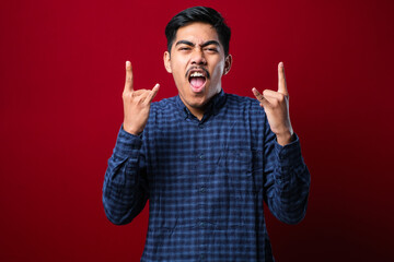 Fototapeta premium Handsome man with mustache wearing casual shirt over red background shouting with crazy expression doing rock symbol with hands up