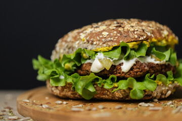 Close up of juicy healthy vegetarian burger on wooden plate