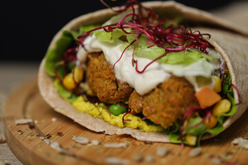 Close up of juicy healthy vegetarian tortilla on wooden plate