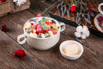 Morning porridge breakfast with sweet berries and butter