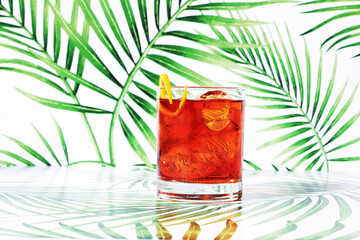 Red Negroni Cocktail on Green Tropical Background
