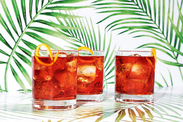 Three Red Negroni Cocktails on Tropical Background