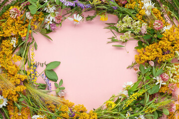 Beautiful wreath of wild flowers , typical Scandinavian midsummer decoration concept. Pink background. Top view - obrazy, fototapety, plakaty