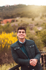 young man posing in the middle of the field dressed in elegant clothes