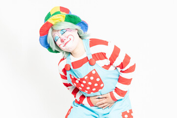 白背景の前に立って、お腹に手を当てるピエロ