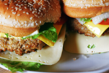 Photos of homemade burgers. Steak and white bun with sesame seeds, cheese and cabbage, tomatoes. Homemade food.