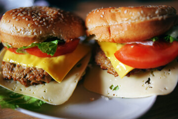 Photos of homemade burgers. Steak and white bun with sesame seeds, cheese and cabbage, tomatoes. Homemade food.