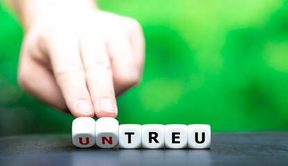 Hand dreht W&uuml;rfel und &auml;ndert das Wort "untreu" in "treu".